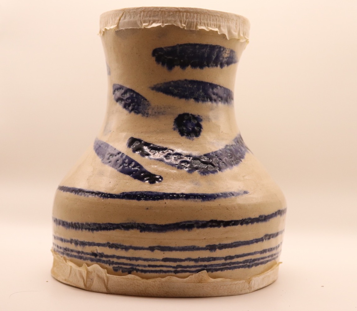 Front of a finished ceramic darbuka with blue brush marks
