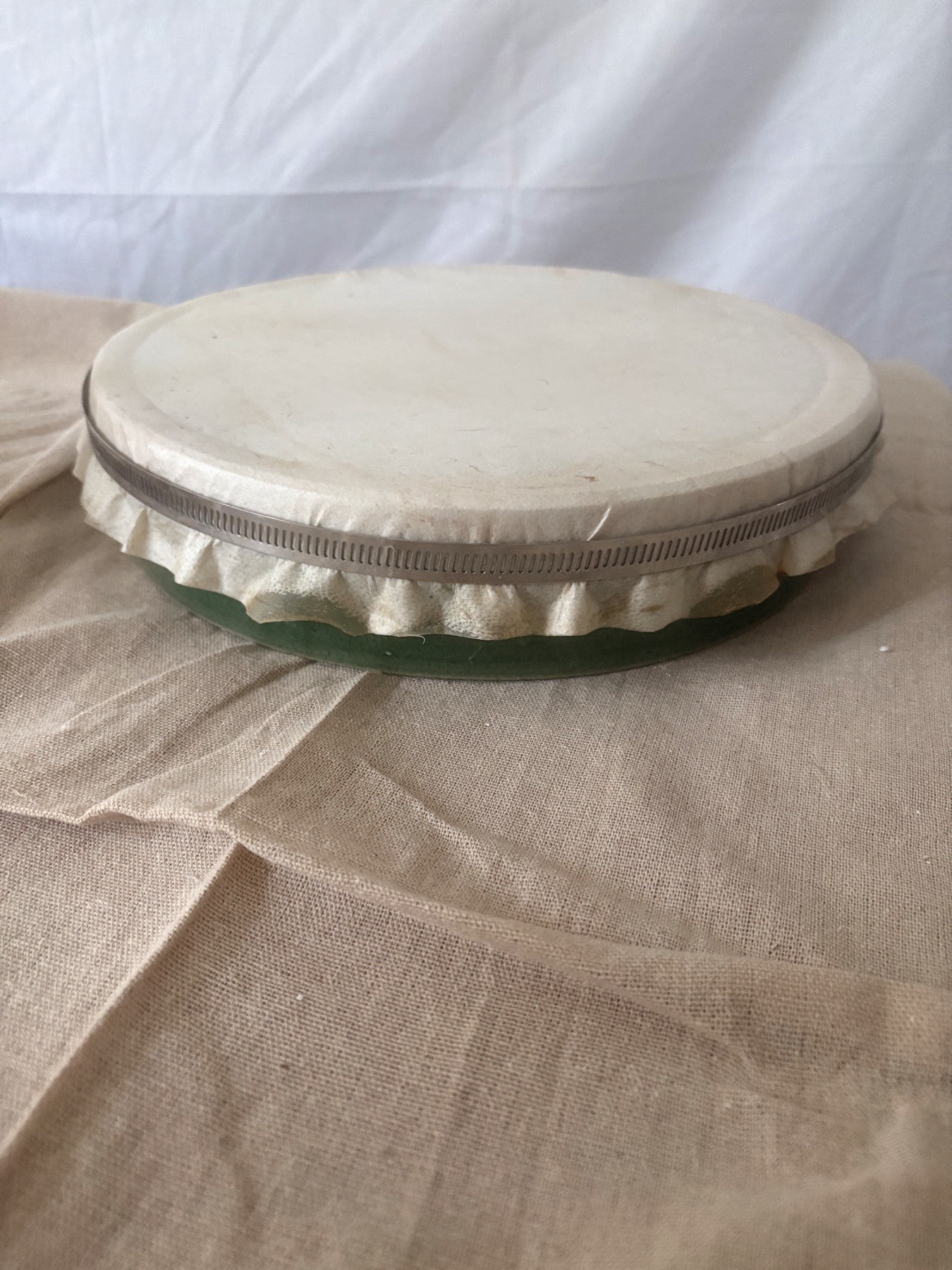 Ceramic bodhran with a goat-skin head attached and drying