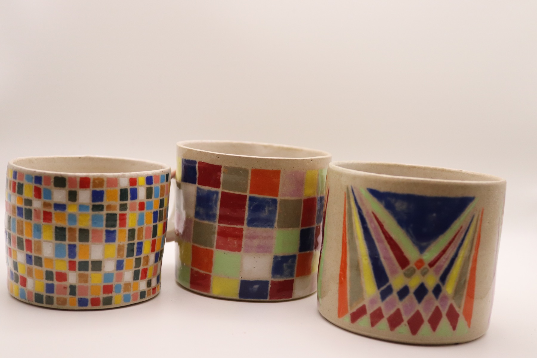 Three handmade mugs with colourful mosaic and geometric decoration