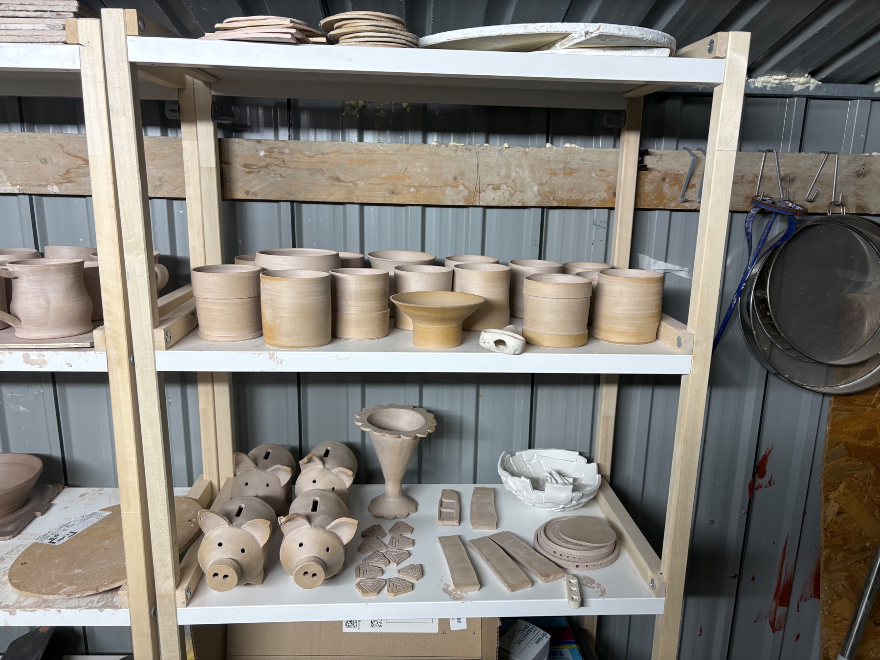 Bisque-fired pottery stacked on kiln shelves